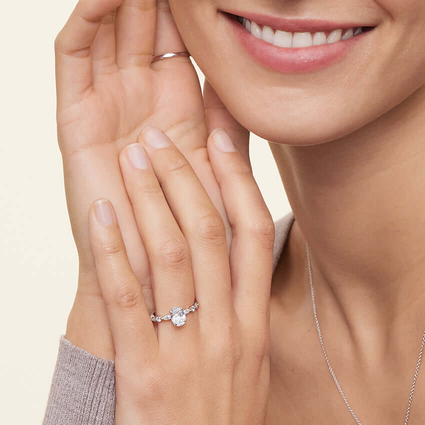 model wearing round and marquise claw prong brilliant cut lab diamond engagement ring