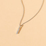 white gold bar pendent with 5 diamonds on background