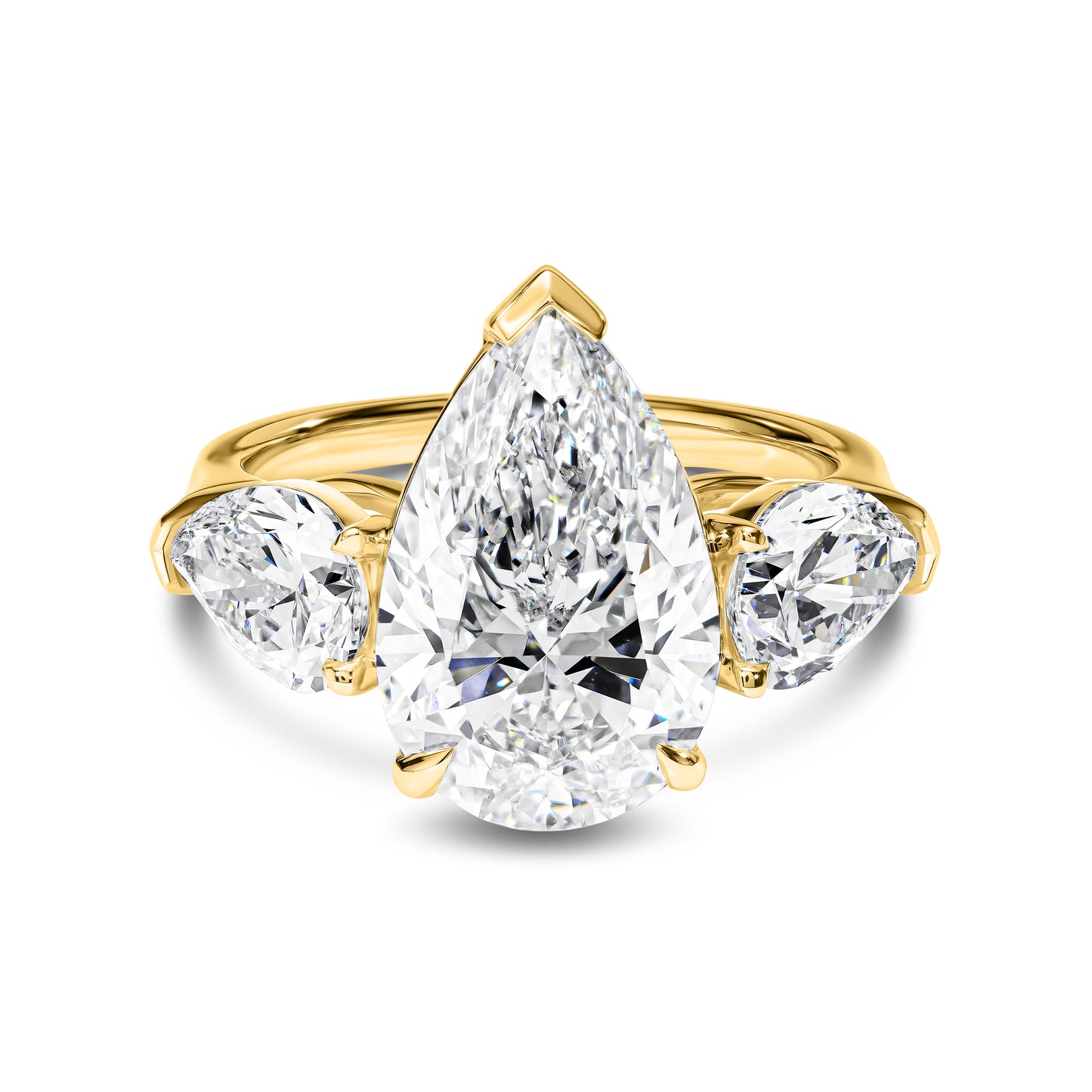 Gold ring with a pear-shaped diamond and two side stones on a white background