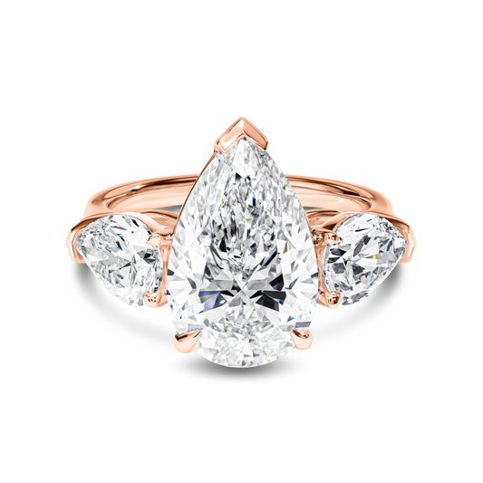 Rose gold ring with pear-shaped diamond on a white background
