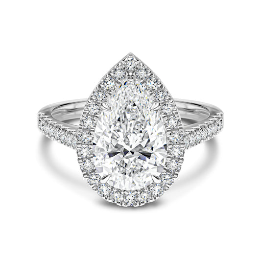 Diamond ring with pear-shaped center stone and halo on a white background