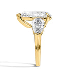 Gold ring with a pear-shaped diamond on a white background